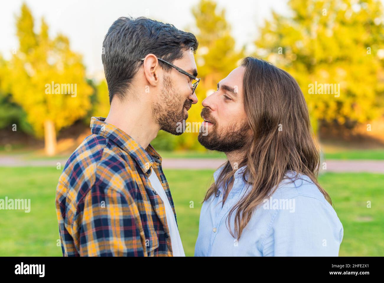 couple romantique gay masculin face à face dans un parc Banque D'Images