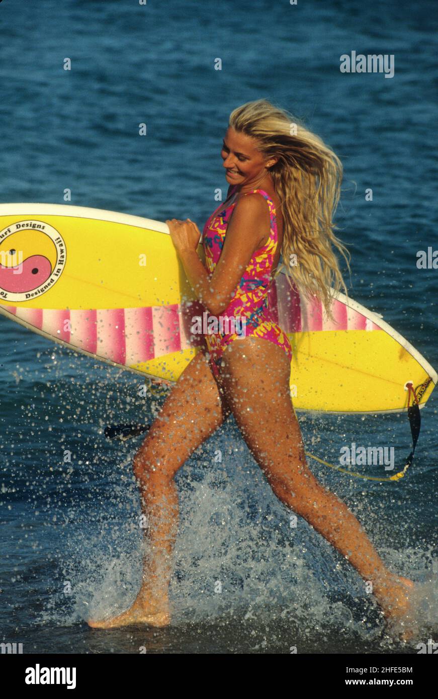 beauté attrayant cheveux blond sportive dos silhouet profil courant barbotage vagues holdin surf fond d'eau de mer Banque D'Images