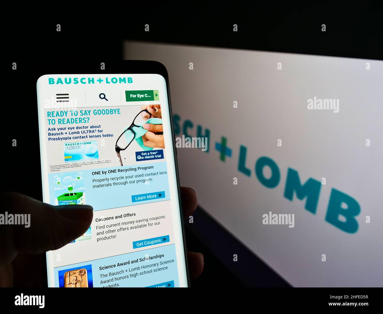 Personne tenant un téléphone cellulaire avec le site Web de la société canadienne de santé oculaire Bausch + Lomb à l'écran devant le logo.Concentrez-vous sur le centre de l'écran du téléphone. Banque D'Images