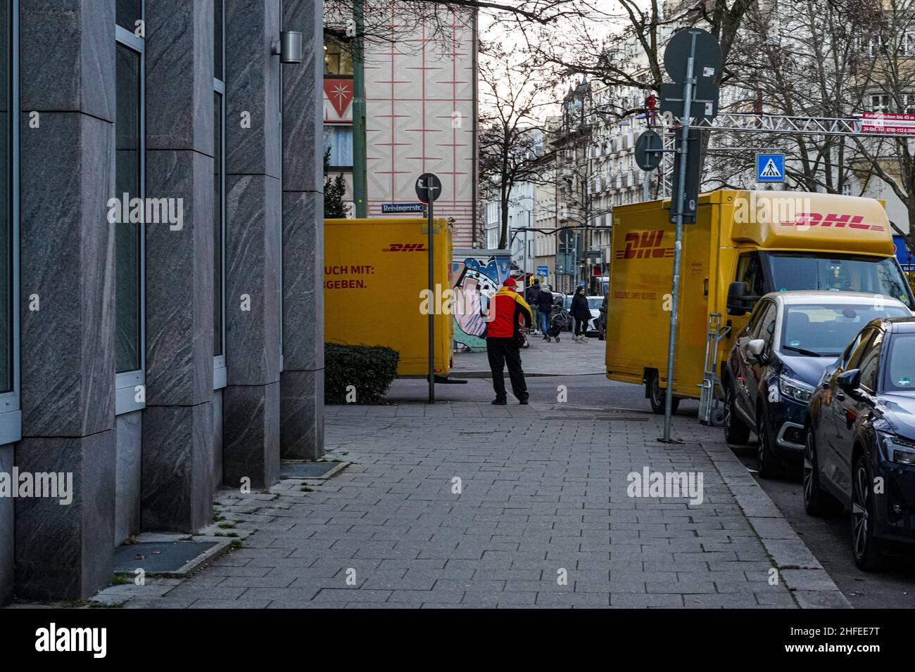 Deux arrêts de livraison de colis DHL à un carrefour.Entre les deux un transporteur de livraison DHL. Banque D'Images