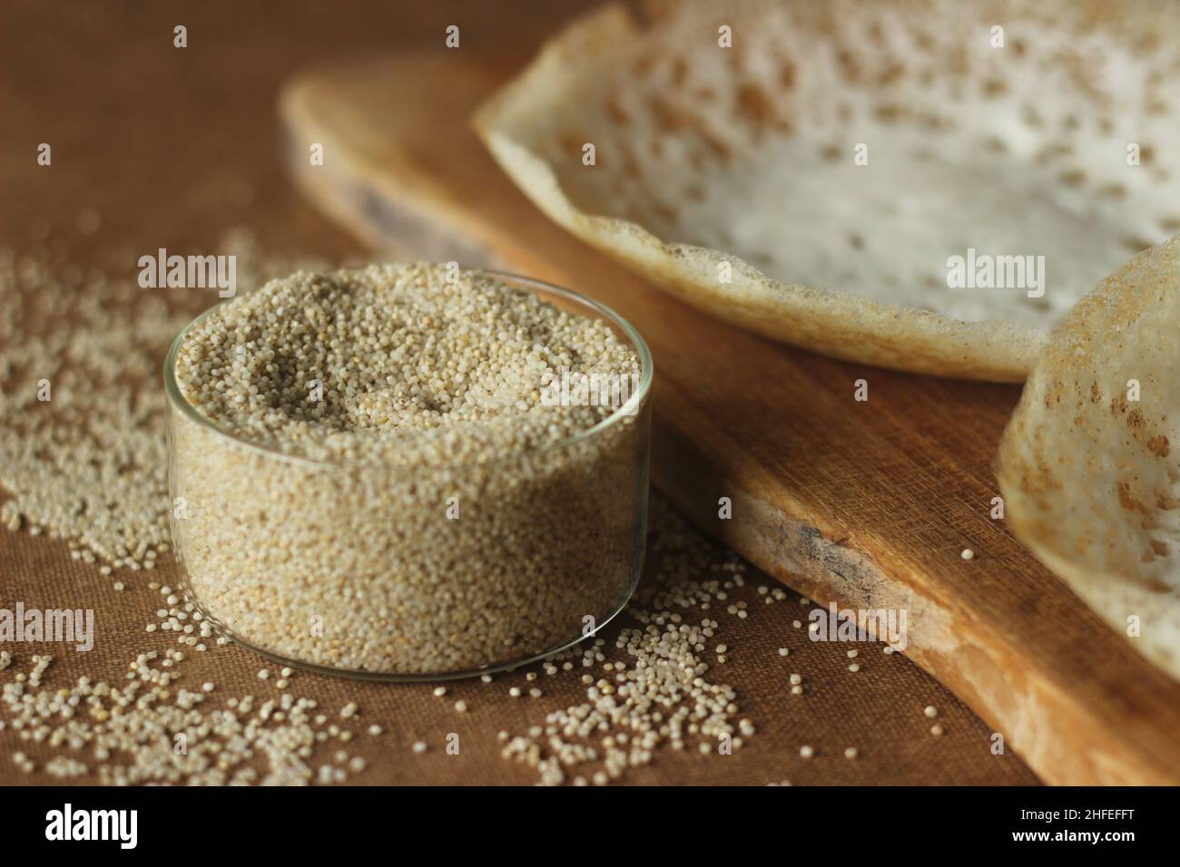 Millet de baryard dans un bol en verre à côté de crêpes lacées de millet de baryard.Ce millet est également connu comme millet japonais, cultivé sur une petite échelle en I Banque D'Images