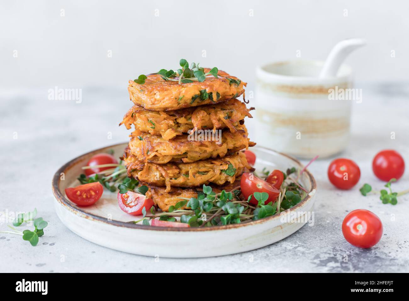 Beignets de pommes de terre aux herbes végétaliennes servis avec une salade fraîche Banque D'Images