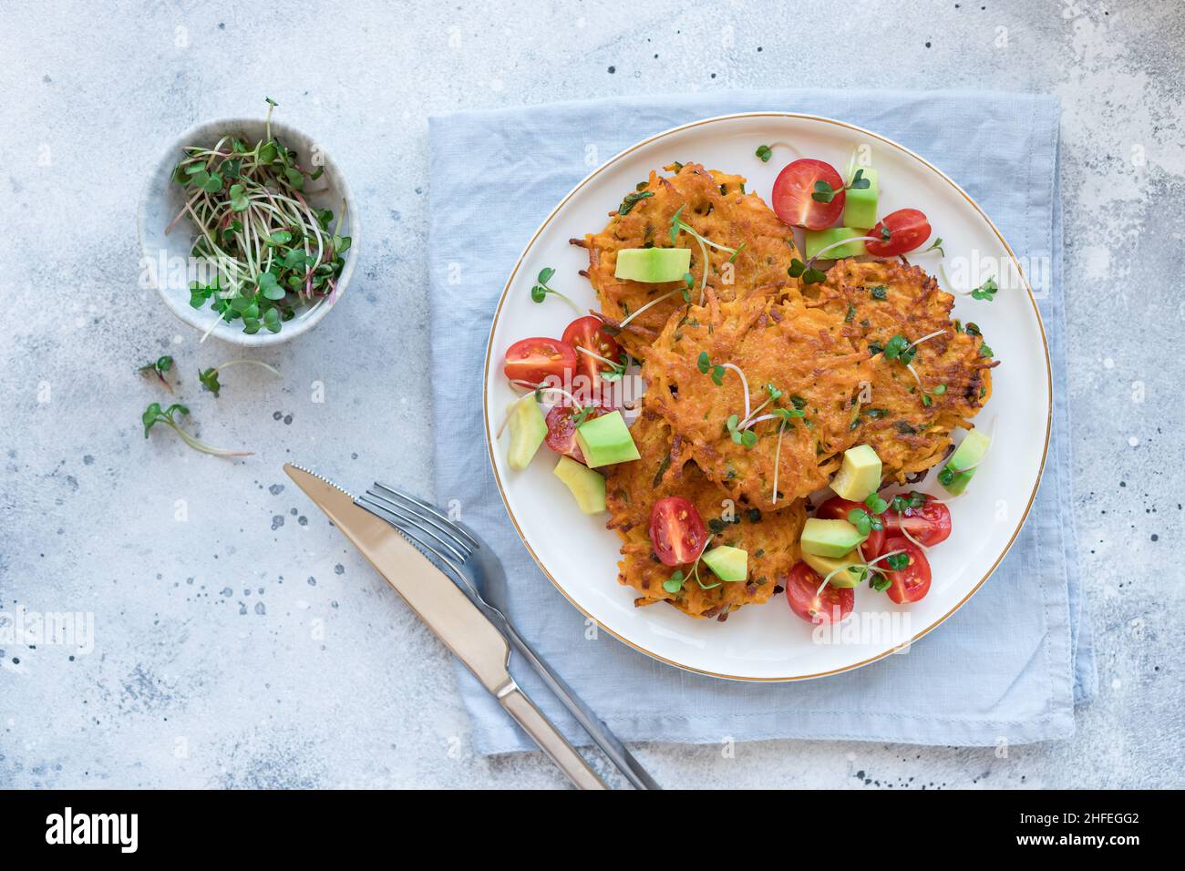 beignets de patates végétaliens, servis avec de l'avocat, de la tomate et des micro-légumes Banque D'Images