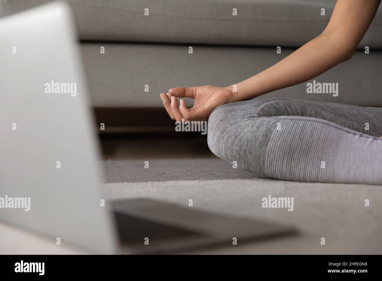 Gros plan sur la main femelle repliée reposant sur le genou. Banque D'Images