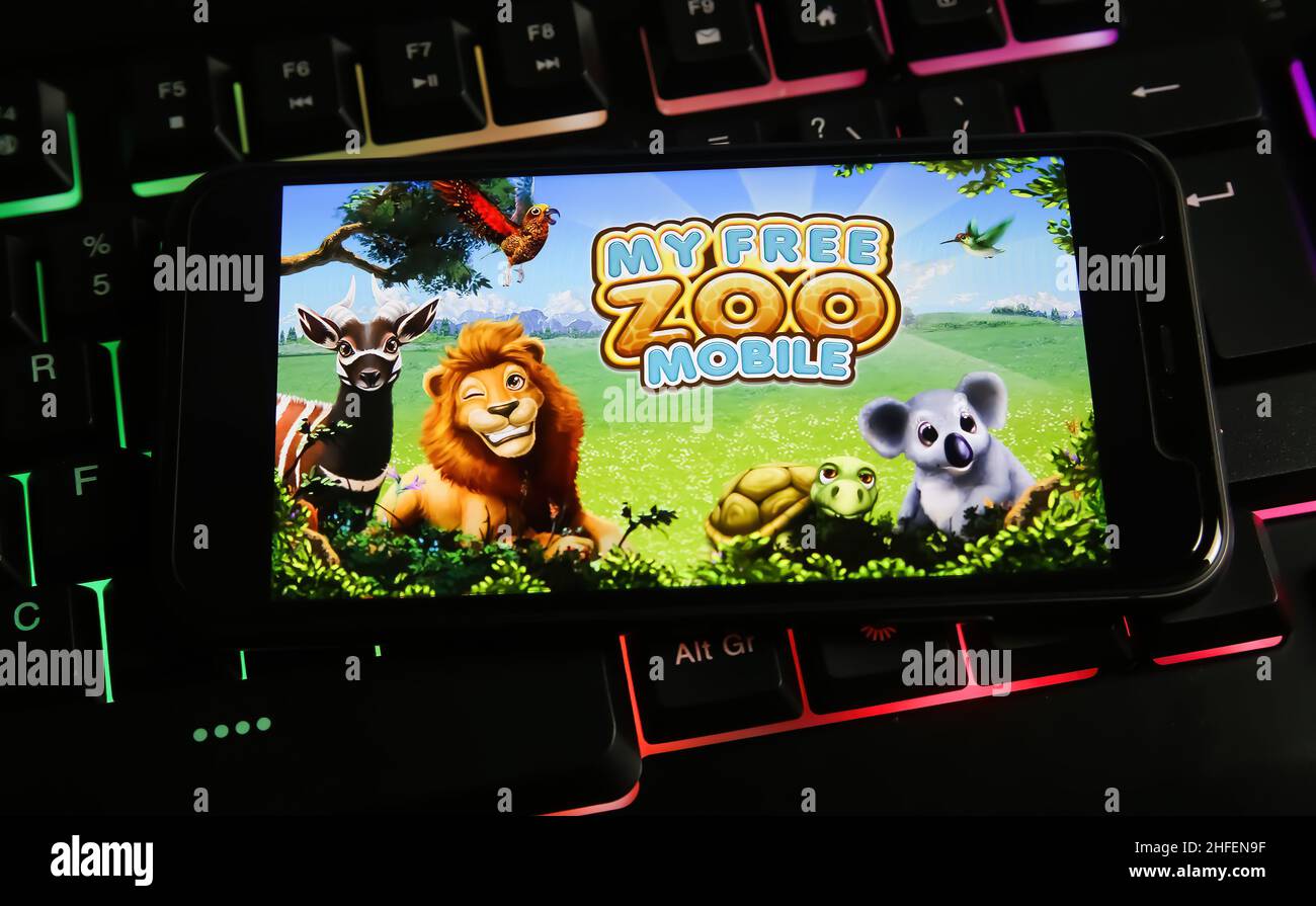 Viersen, Allemagne - janvier 9.2022: Gros plan de téléphone mobile avec logo lettrage de jeu de pc mon zoo gratuit sur le clavier d'ordinateur Banque D'Images