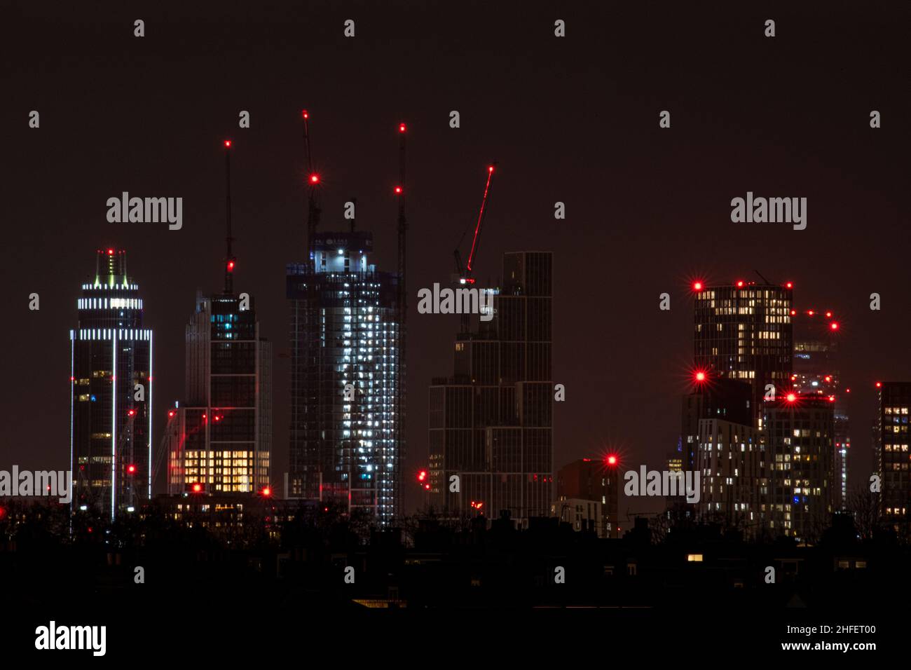 Grues et bâtiments de grande hauteur, dont la tour St Georges Un horizon londonien de nuit Banque D'Images