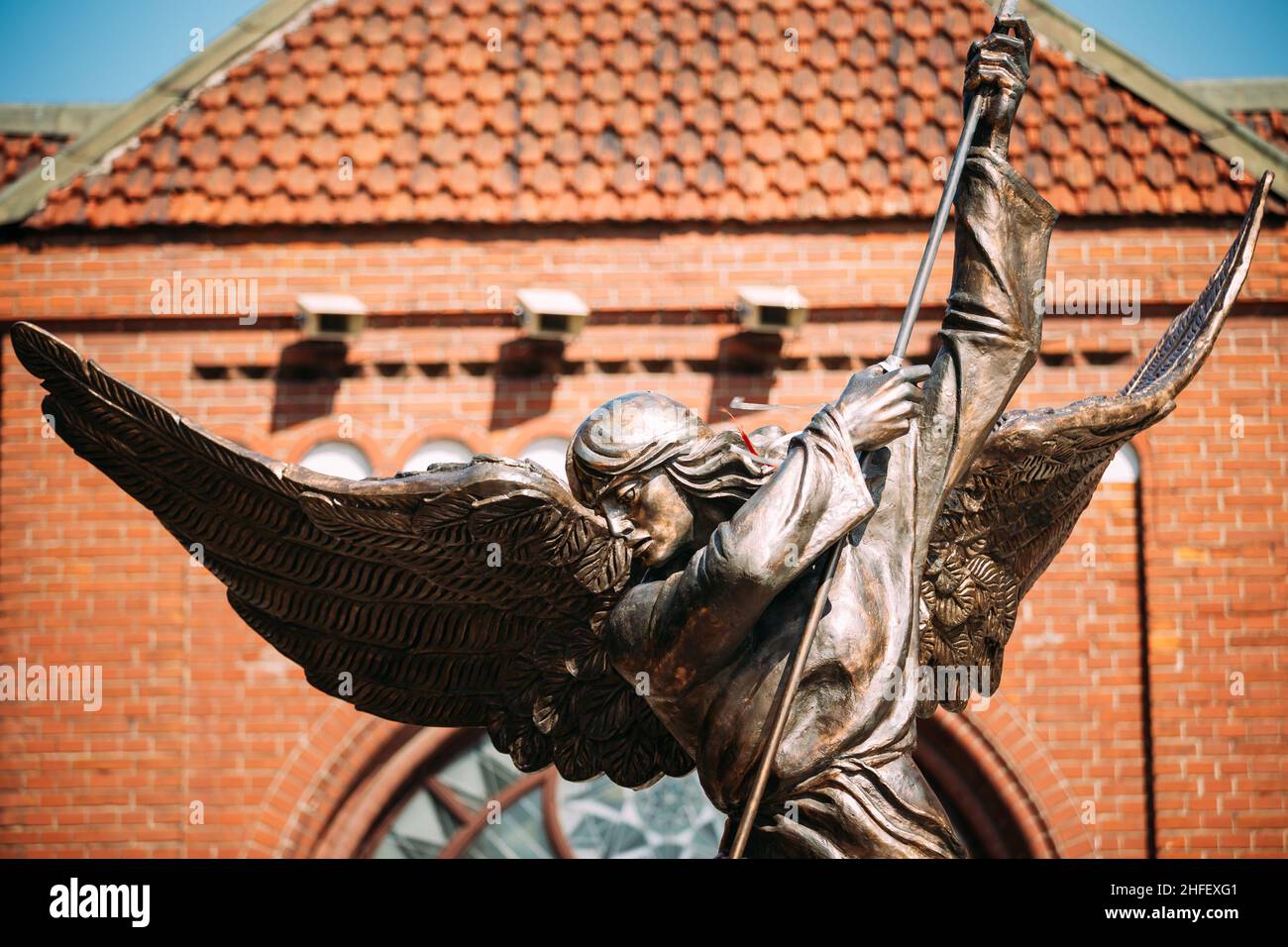 Statue de l'Archange Michel près de l'église catholique rouge de Saint-Simon et Sainte-Hélène sur la place de l'indépendance à Minsk, en Biélorussie Banque D'Images