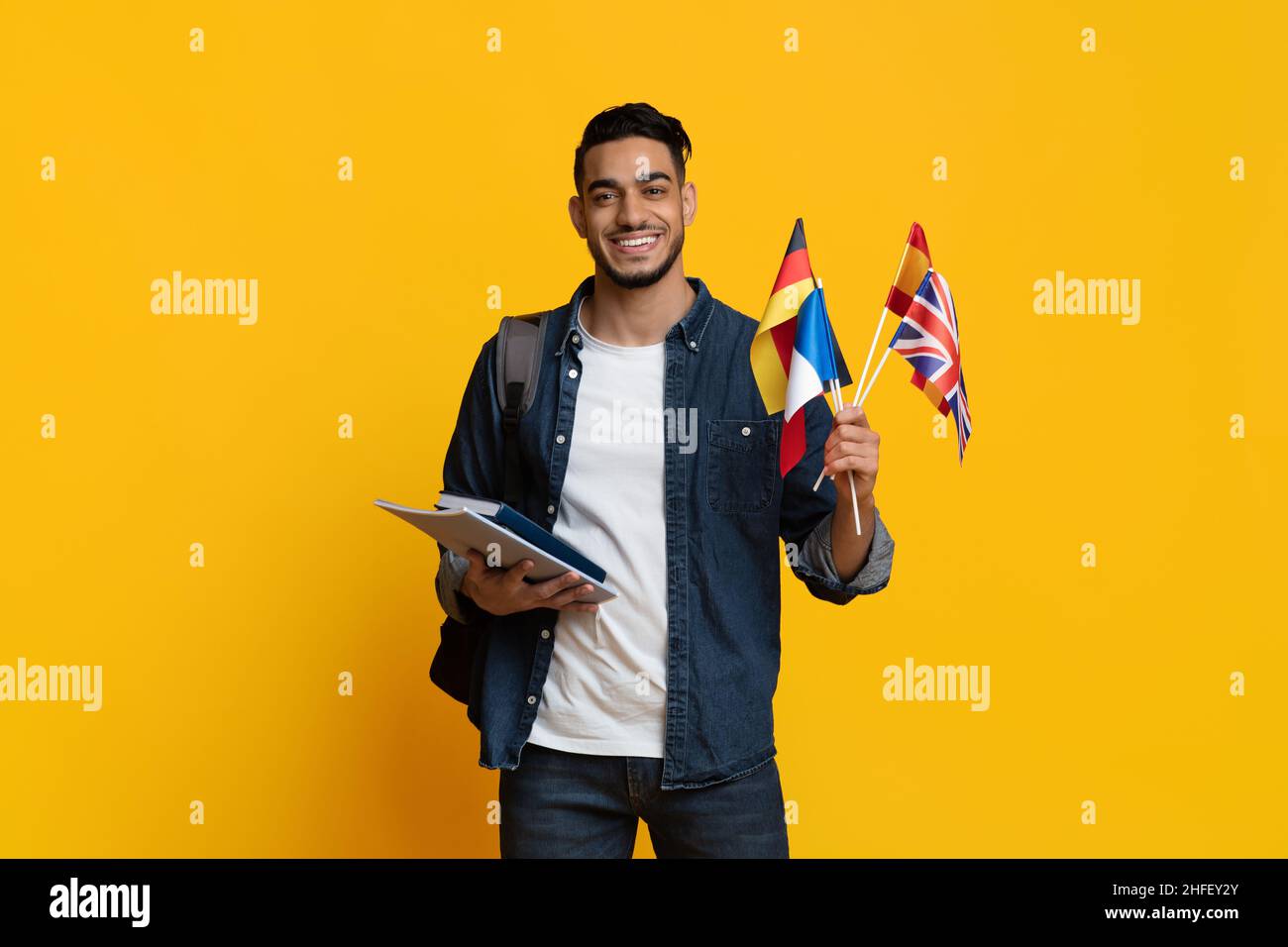 Un étudiant positif du Moyen-Orient montrant des drapeaux de différents pays Banque D'Images