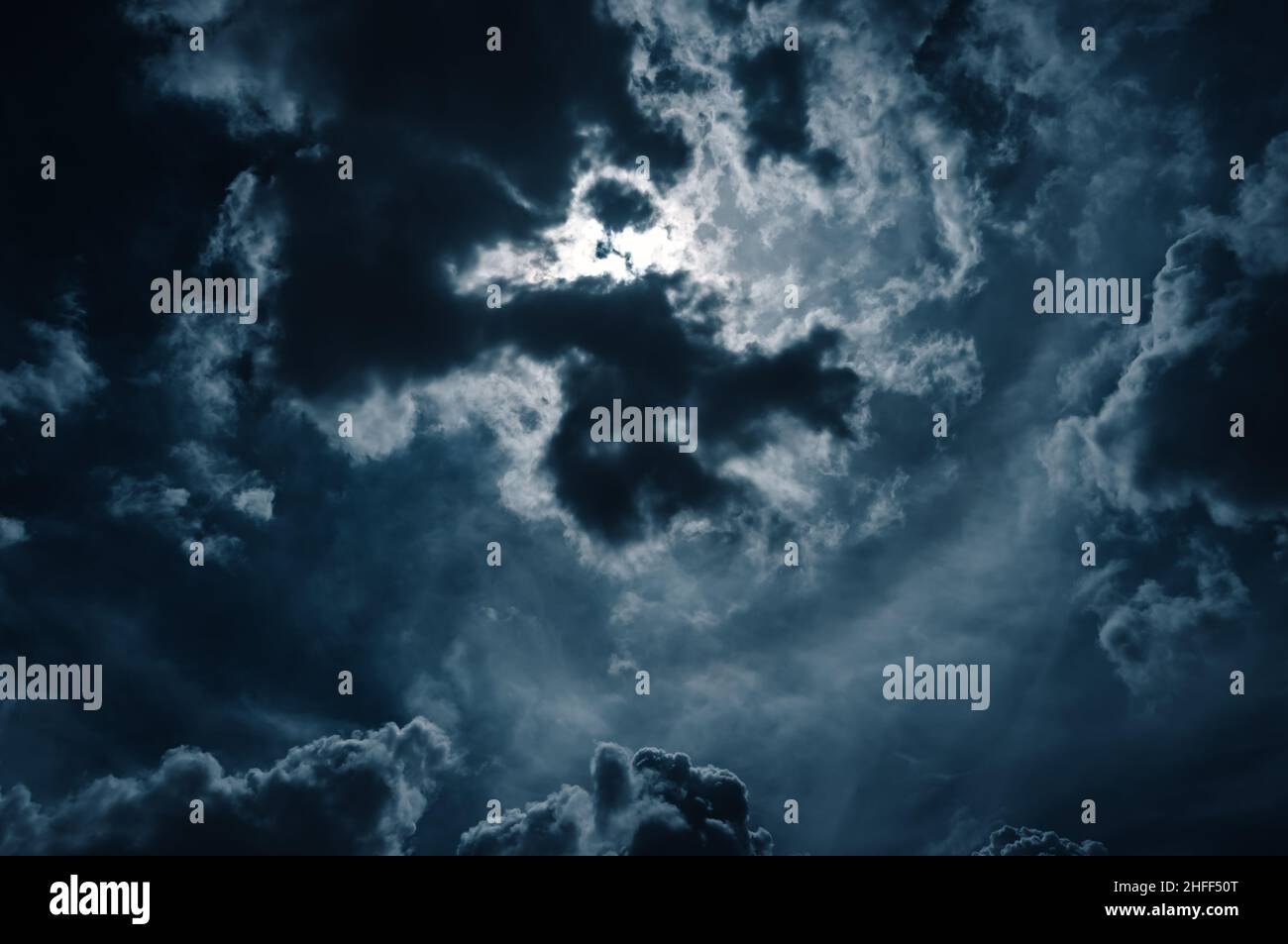 Clair de lune brille derrière un ciel nuageux la nuit. Sérénité nature fond. Banque D'Images