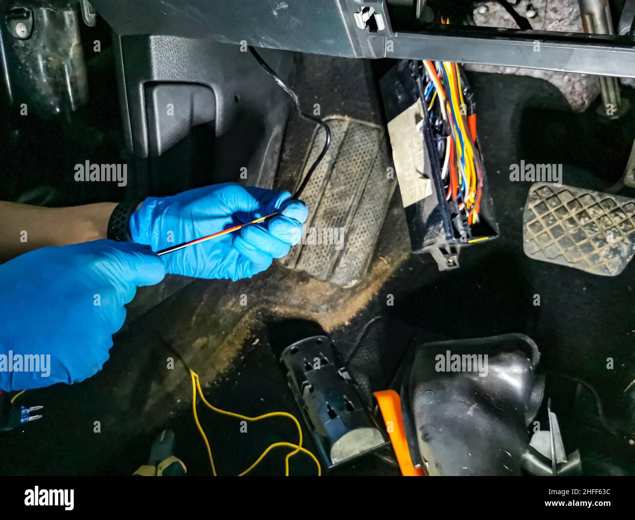 un électricien maître répare les câbles dans une voiture moderne Banque D'Images