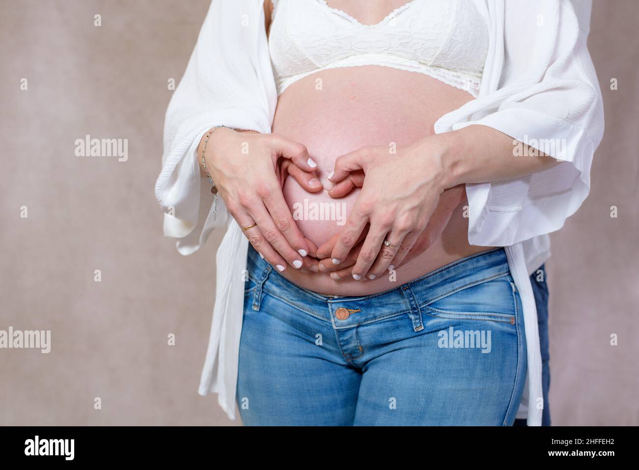 Ventre enceinte avec ruban rouge.Neuf mois.Troisième trimestre Banque D'Images