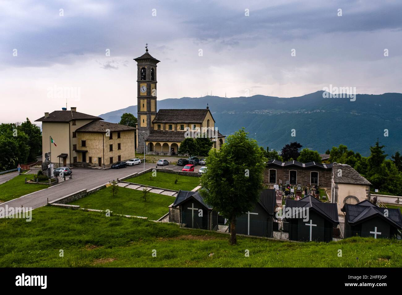 L'église locale de Fuipiano Chiesa di San Giovanni Battista et le cimetière attenant, entourant les collines au loin. Banque D'Images