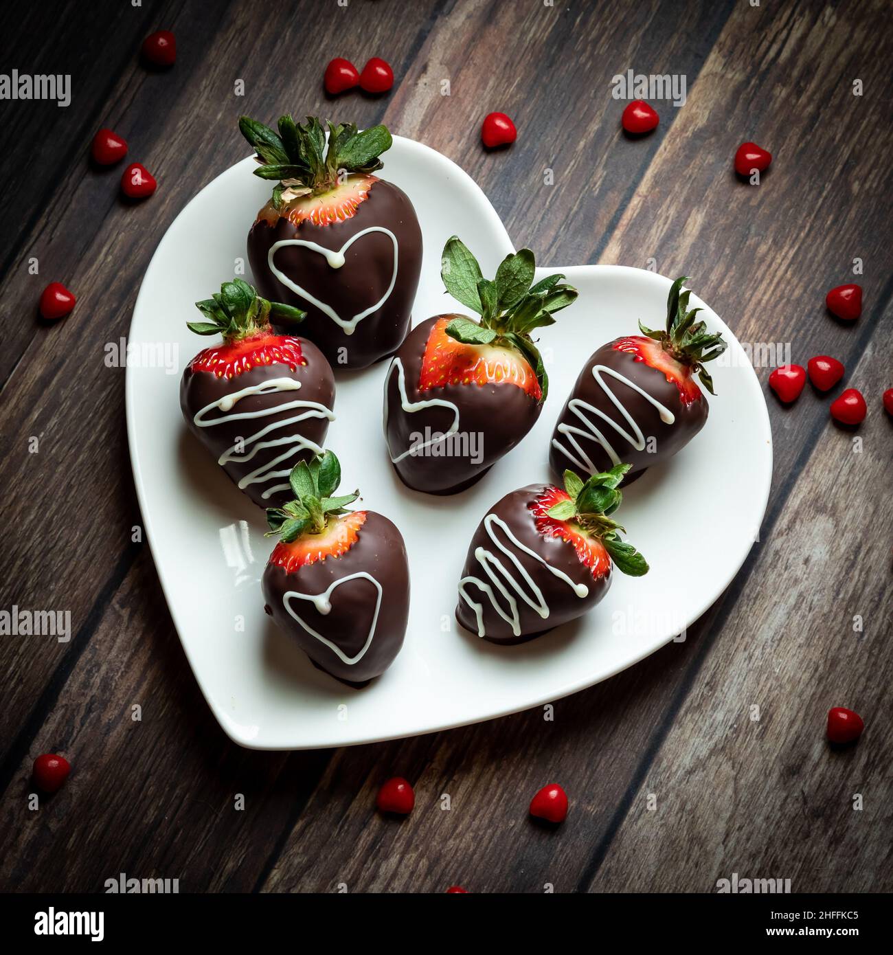 Vue de haut en bas d'une assiette en forme de coeur remplie de fraises enrobées de chocolat Banque D'Images