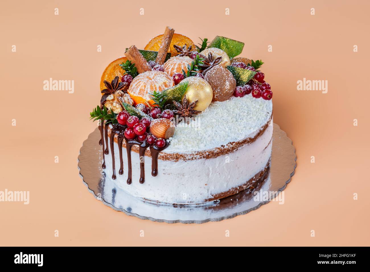 Fruit de Noël décoré de gâteau au chocolat blanc fait maison et de décorations pour le nouvel an.Sur fond jaune. Banque D'Images
