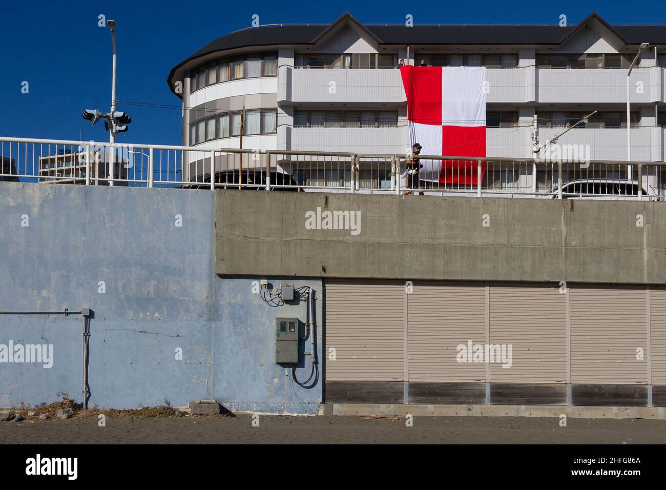 Enoshima, Japon.16th janvier 2022.Un grand drapeau maritime pour U-Uniform, qui signifie que vous vous dirigez vers le danger, est suspendu des balcons d'un bâtiment pour avertir les navires du risque de tsunami à Enoshima.Une énorme éruption volcanique sous-marine près de la nation des Tonga de l'île du pacifique Sud, samedi soir, a déclenché des avertissements de tsunami dans le Pacifique.Des vagues atteignant un mètre de haut frappent certaines parties de la côte japonaise tôt dimanche.Crédit : SOPA Images Limited/Alamy Live News Banque D'Images