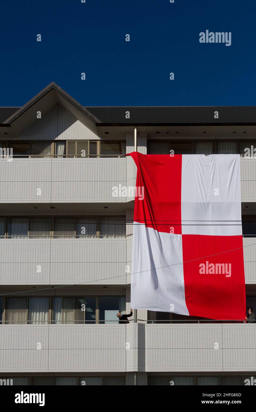 Enoshima, Japon.16th janvier 2022.Un grand drapeau maritime pour U-Uniform, qui signifie que vous vous dirigez vers le danger, est suspendu des balcons d'un bâtiment pour avertir les navires du risque de tsunami à Enoshima.Une énorme éruption volcanique sous-marine près de la nation des Tonga de l'île du pacifique Sud, samedi soir, a déclenché des avertissements de tsunami dans le Pacifique.Des vagues atteignant un mètre de haut frappent certaines parties de la côte japonaise tôt dimanche.Crédit : SOPA Images Limited/Alamy Live News Banque D'Images