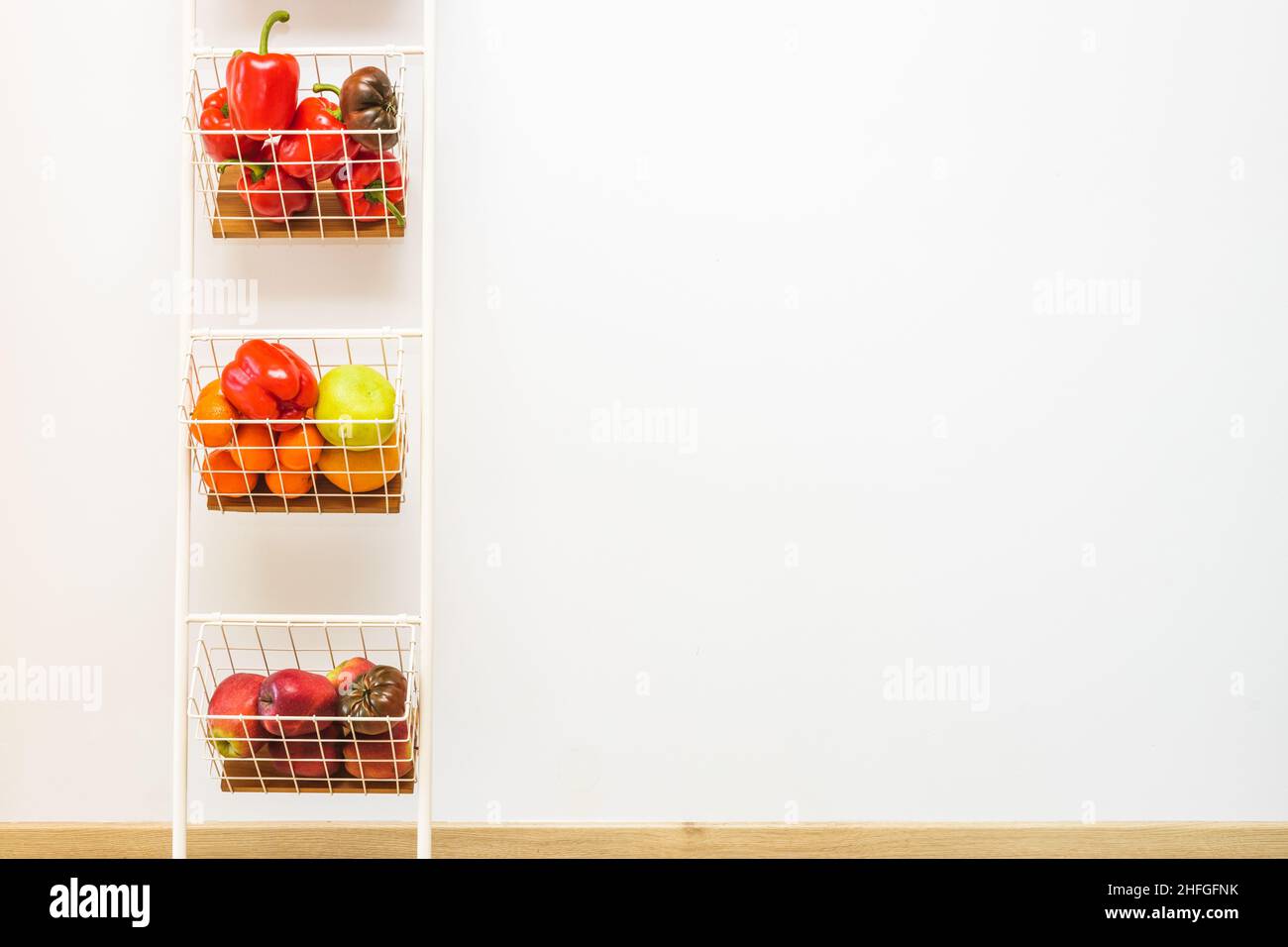 Portoir vertical blanc avec étagères pleines de légumes et de fruits, espace de texte Banque D'Images