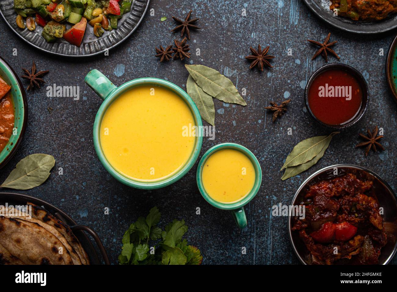 Saine cuisine indienne Ayurveda buvez du lassi de mangue dans deux tasses sur une table rustique en béton Banque D'Images