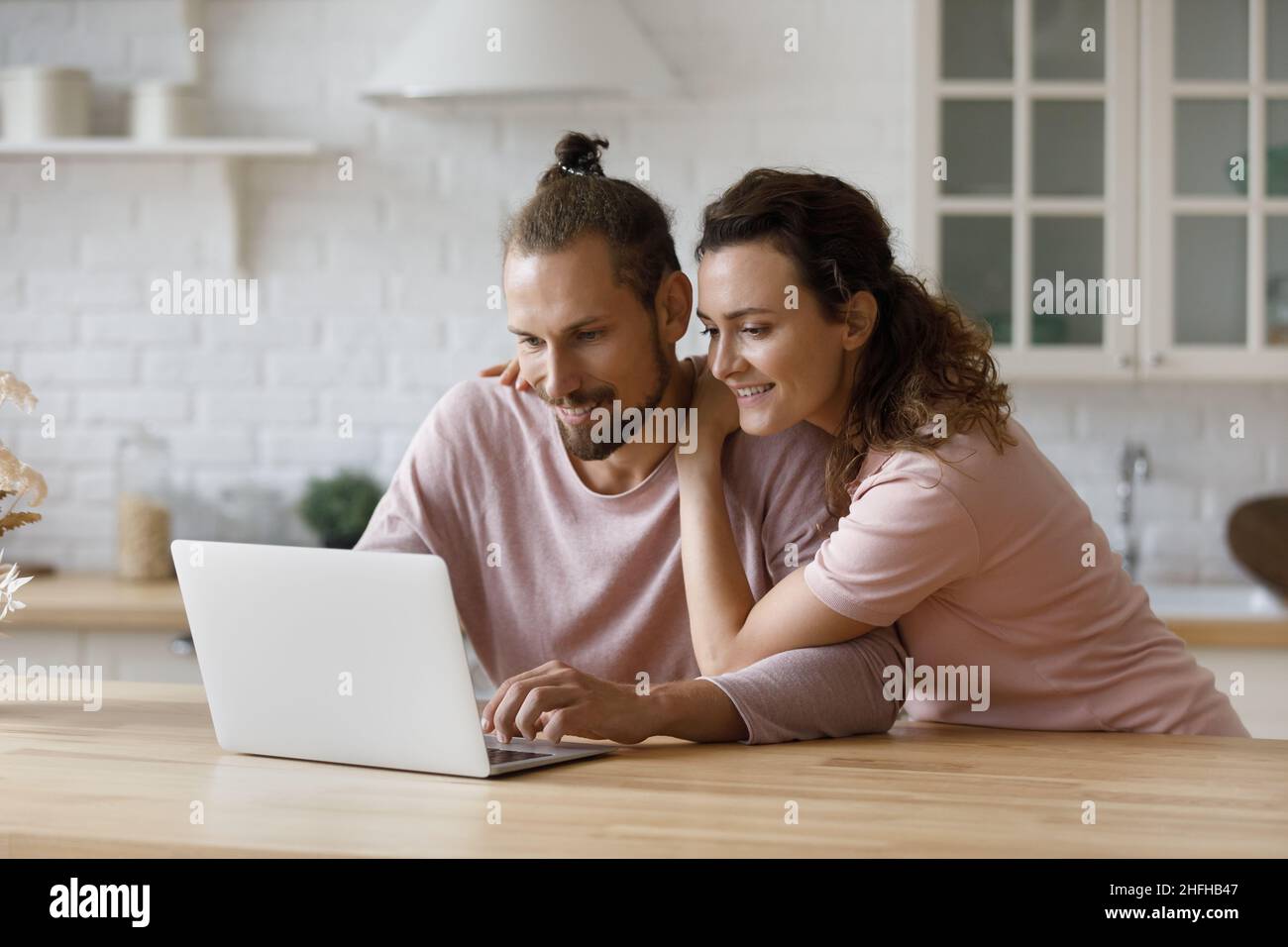 Couple familial millénaire affectueux et affectueux utilisant des applications informatiques. Banque D'Images