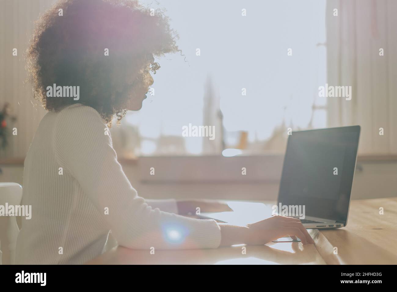 Lady avec la peau parfaite sombre tenant la carte de crédit et l'insertion des informations bancaires pour les achats en ligne se trouve près de l'ordinateur portable de près Banque D'Images