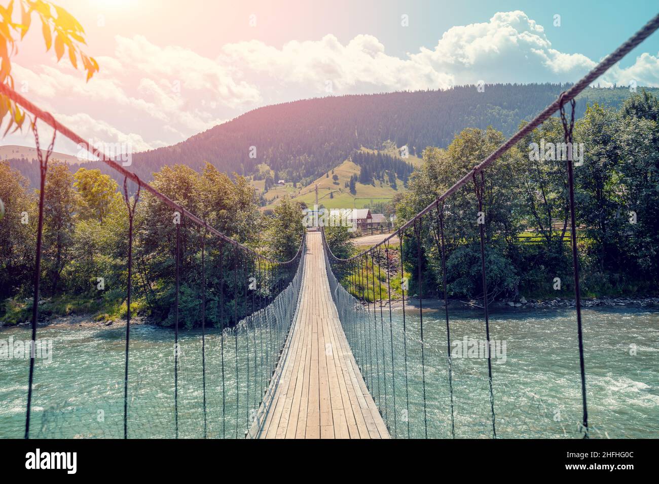 Pont suspendu en bois au-dessus d'une rivière de montagne Banque D'Images