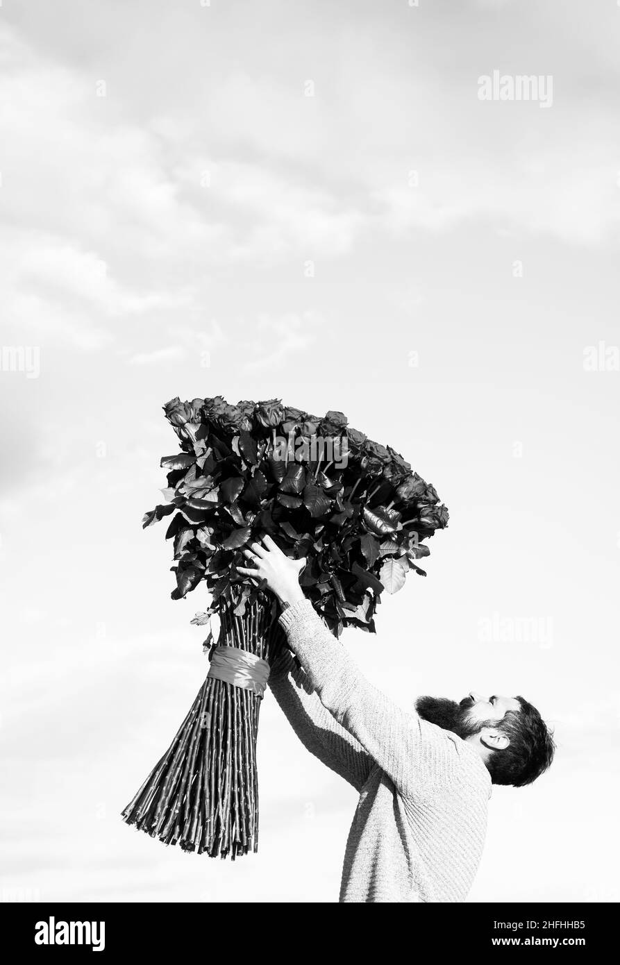 Petit ami homme avec bouquet de roses. Concept de cadeaux de la Saint-Valentin. Un bel homme qui donne des fleurs à sa petite amie. Banque D'Images