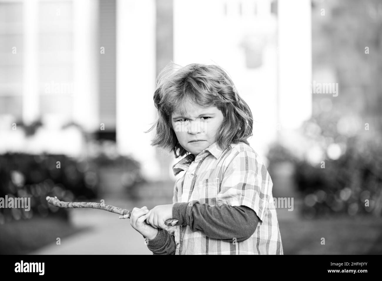 Conflit d'enfants. Agression d'enfant. Concept d'émotion négative. Garçon bouclé en colère avec bâton de danger. Adaptation des enfants. Le concept d'intimidation. La dépression nerveuse. Banque D'Images