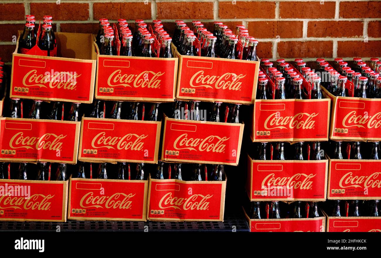 Boîtes de Coca-Cola en bouteilles de verre sur le mur de brique Banque D'Images