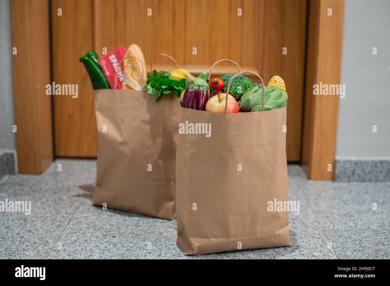 Des sacs de shopping de nourriture sont à la porte de la maison ou de l'appartement.Livraison de légumes et de fruits pendant la quarantaine et l'auto-isolement. Banque D'Images