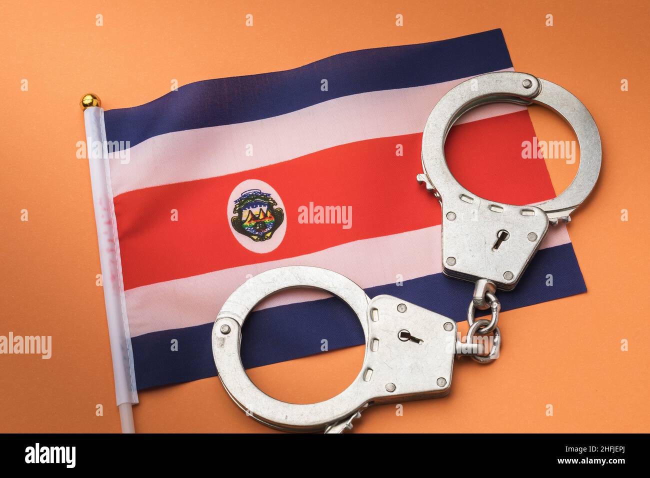 Drapeau du Costa Rica et menottes sur fond coloré, un concept sur le thème de la criminalité au Costa Rica, vue du dessus Banque D'Images