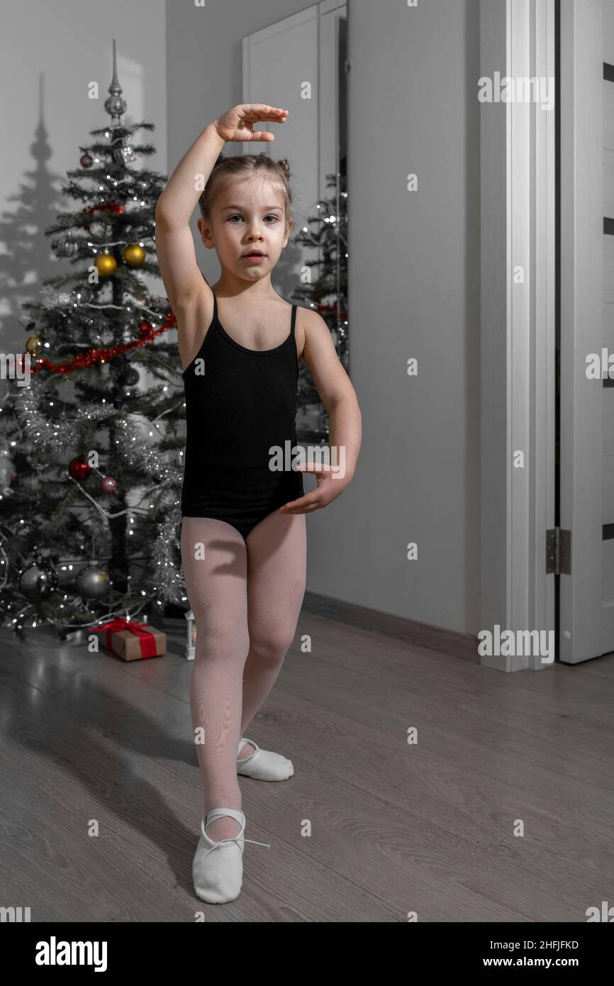 Élégante figure de ballet d'enfant fille par arbre de noël à la maison Banque D'Images