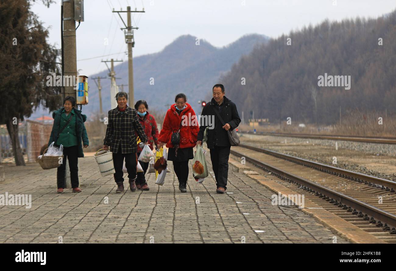 (220117) -- DANDONG, le 17 janvier 2022 (Xinhua) -- les villageois transportant leurs marchandises se préparent à monter à bord d'un « train lent » à la gare de Shicheng, dans la ville de Fengcheng, dans la province de Liaoning, au nord-est de la Chine, le 15 janvier 2022.Les trains n° 4317 et 4318 sont des trains « low trains » qui circulent entre Tonghua, dans la province de Jilin, et Dandong, dans la province de Liaoning, dans le nord-est de la Chine.À la veille du nouvel an lunaire, les autorités ferroviaires locales ont organisé des marchés à bord qui permettent aux villageois vivant le long de la route des trains de vendre des marchandises aux passagers sans quitter les wagons.(Xinhua/Yang Qing) Banque D'Images