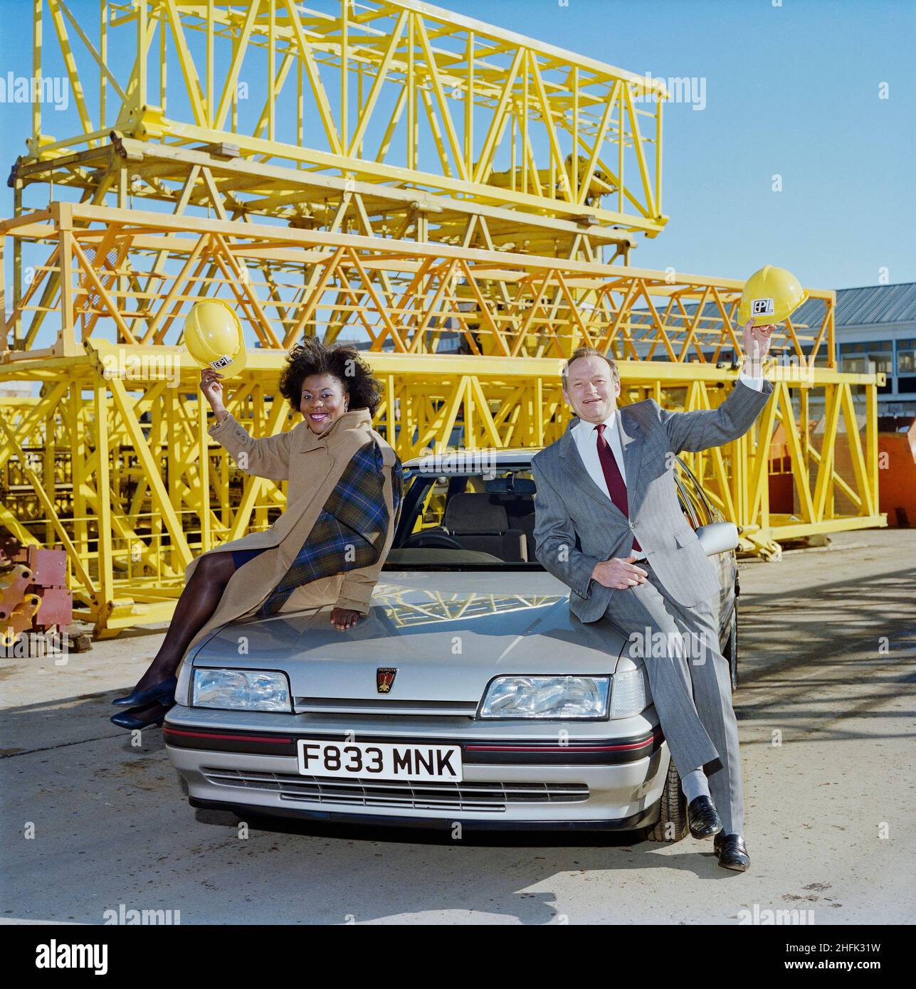 Borehamwood, Elstree et Borehamwood, Hertsmere, Hertfordshire, 23/02/1989.Derek Welsh, directeur général de l'EPL, et Tessa Sanderson, athlète olympique, posant sur le capot de sa voiture Rover sponsorisée, probablement au dépôt de l'EPL à Borehamwood.Tessa Sanderson a conclu une entente de parrainage avec EPL, qui fait partie du groupe Laing. Banque D'Images