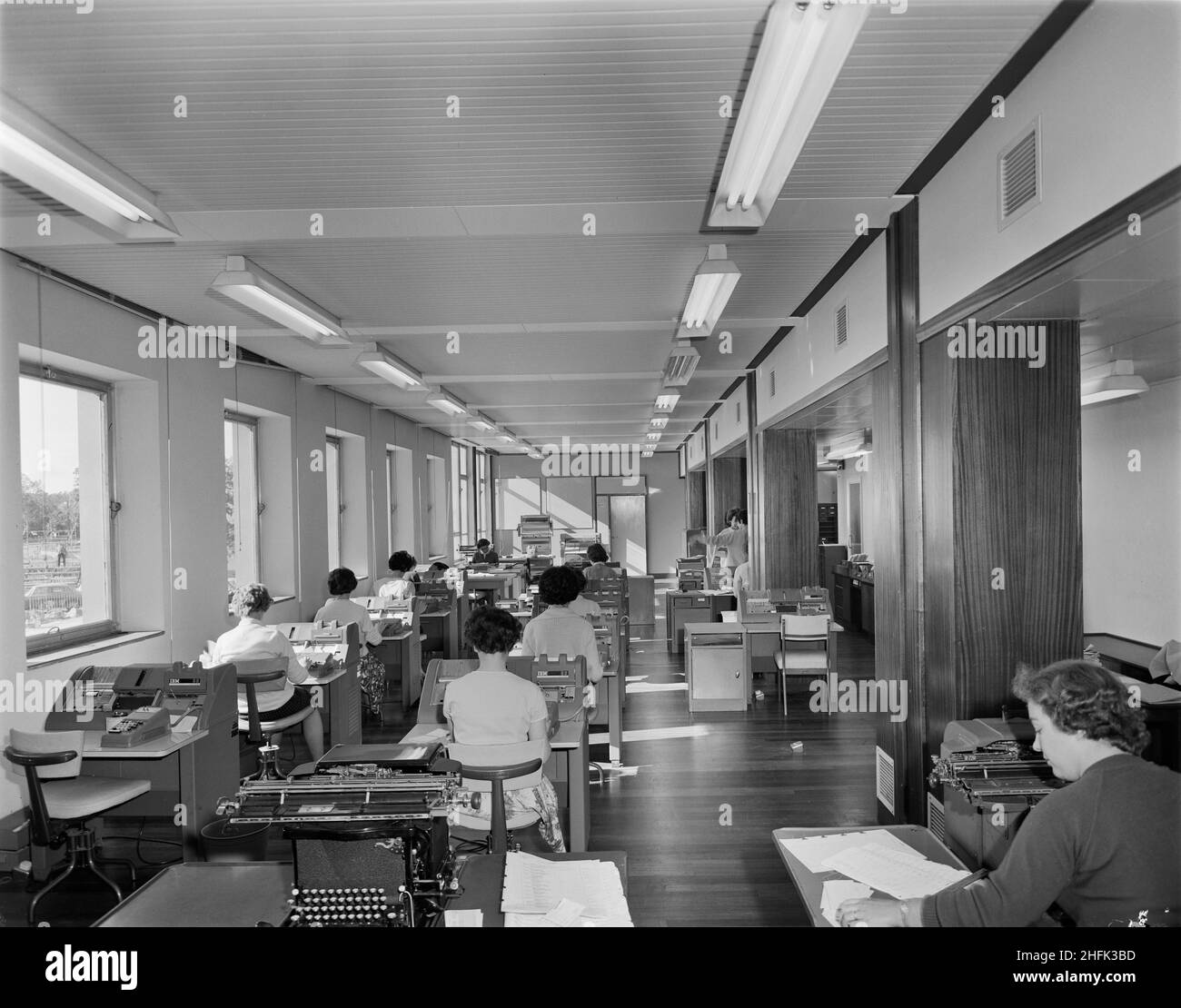 County Hall, A6352, Aykley Heads, Durham, comté de Durham,24/09/1963.Les employés de bureau qui utilisent des machines de vérification de cartes IBM 056 dans les nouveaux bureaux du comté de Durham.Un keypunch était un dispositif utilisé pour perforer avec précision des trous dans des cartes à des endroits spécifiques, déterminé par les clés heurtés par un opérateur humain.Les opérateurs du vérificateur ont saisi exactement les mêmes données que l'opérateur de la fonction keypunch, puis la machine a vérifié si les données poinçonnées correspondent.La machine IBM 056 était le compagnon de vérification de la perforatrice de carte IBM 024 et de la perforatrice de carte IBM 026. Banque D'Images