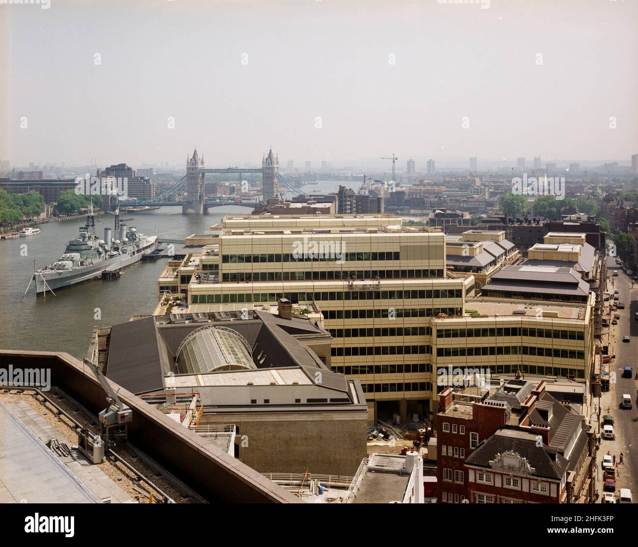 London Bridge City, Southwark, Greater London Authority, 19/06/1986.Vue vers l'est sur le complexe London Bridge City, montrant le HMS Belfast amarré sur la Tamise avec Tower Bridge au-delà.Divers bâtiments de ce complexe de bureaux, d'appartements et de boutiques sur la rue Tooley à London Bridge City ont été construits par Laing Management Contracting pour le groupe St Martins qui a redéveloppé l'ancien site Hay's Wharf sur la rive sud de la Tamise.Le réaménagement du site s'est déroulé sur 2 1/2 ans entre 1985-1988 et comprenait le pont no 1 de London, Cottons, Hays Galleria et 29-33 Banque D'Images