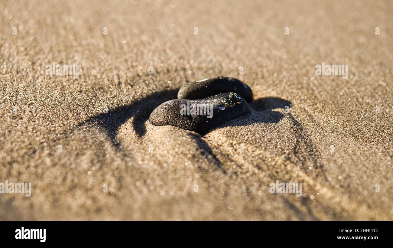Pierre en forme de coeur dans le sable de la plage sur la mer Baltique.Symbole romantique pour les amoureux.Petit signe comme la vie. Banque D'Images