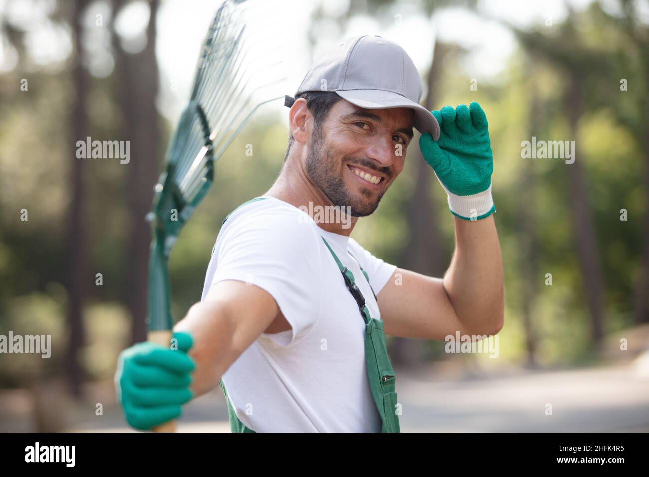 Homme de flou artistique le ratissage des feuilles au jardin Banque D'Images