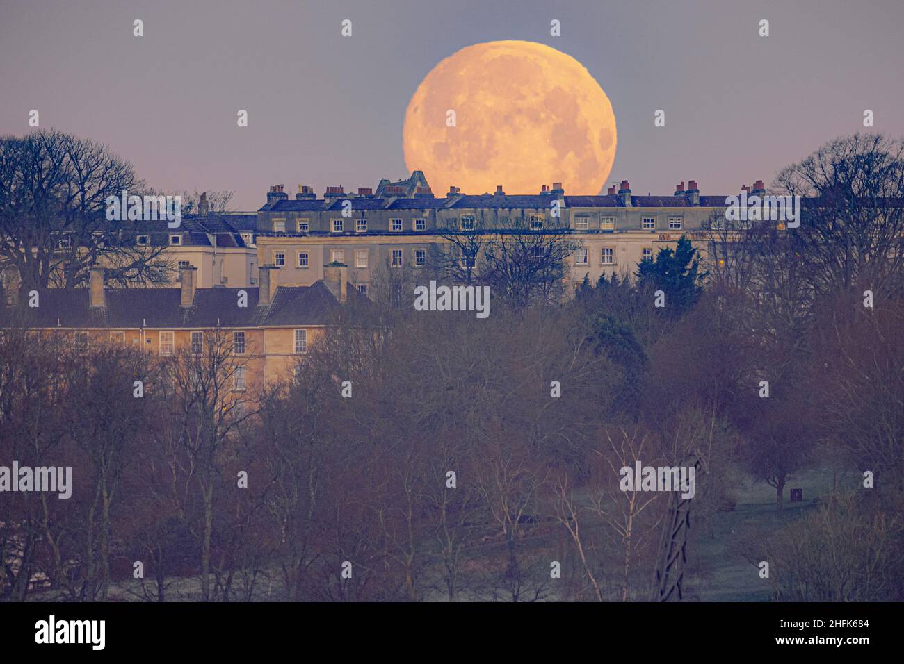 Pix Lune 1 Ville La lune se couche derrière les maisons de Bristol.La première pleine lune  de 2022 - la lune du loup selon les natifs du nord-américain - est lundi  soir.Date de la photo: Lundi