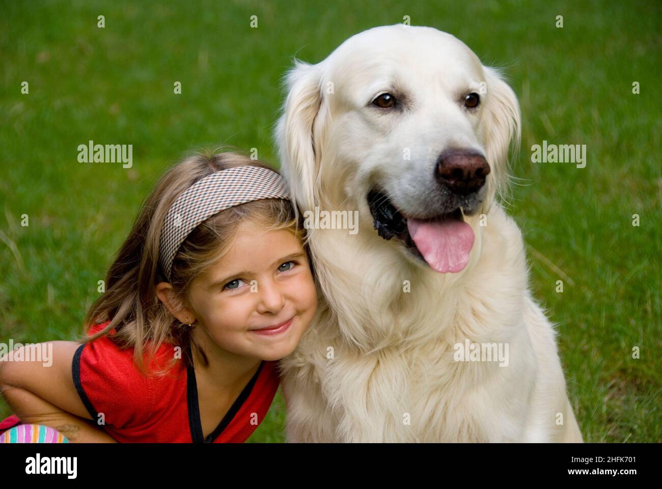 Petite fille de huit ans avec son chien Golden Retriever Banque D'Images