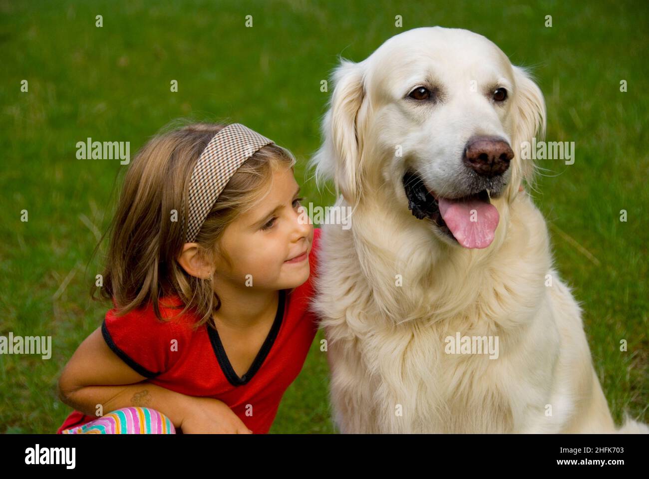 Petite fille de huit ans avec son chien Golden Retriever Banque D'Images