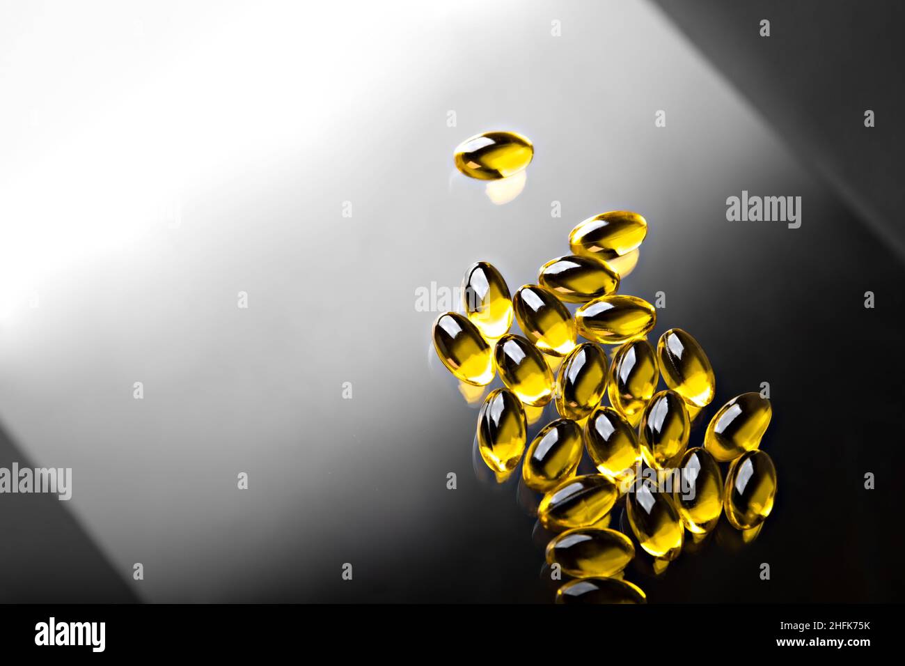 Capsules transparentes à l'huile de poisson Omega 3 sur fond noir et blanc Banque D'Images