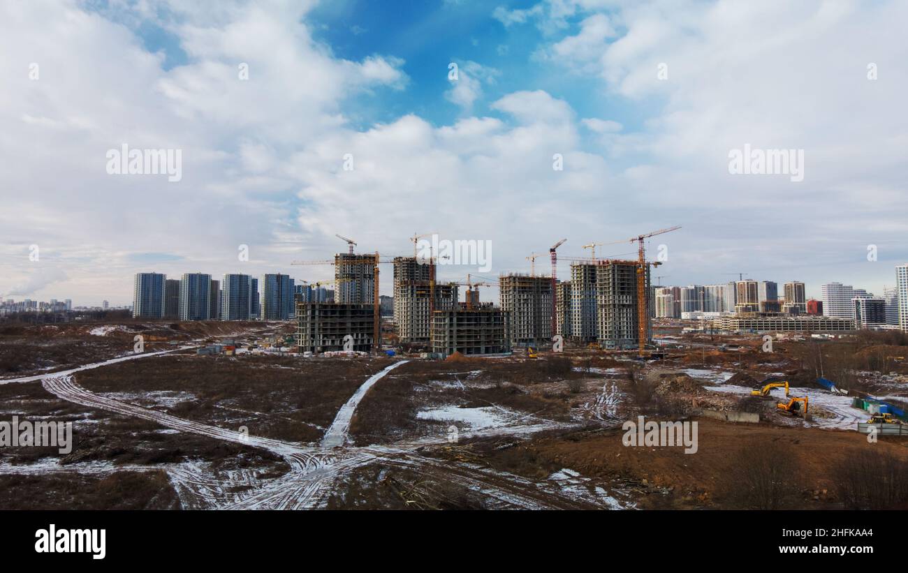 Chantier.Construction de bâtiments modernes en hauteur.Grues de chantier.Terre enneigée.Photographie aérienne. Banque D'Images
