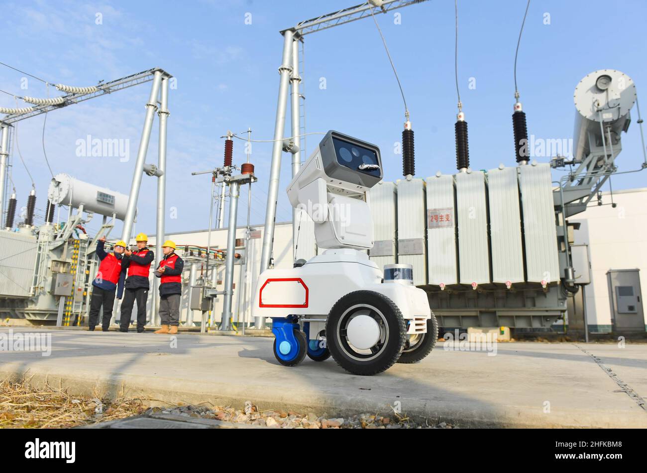 CHUZHOU, CHINE - 17 JANVIER 2022 - Un robot d'inspection intelligent 5G travaille avec le personnel d'exploitation et de maintenance pour inspecter l'équipement d'alimentation Banque D'Images
