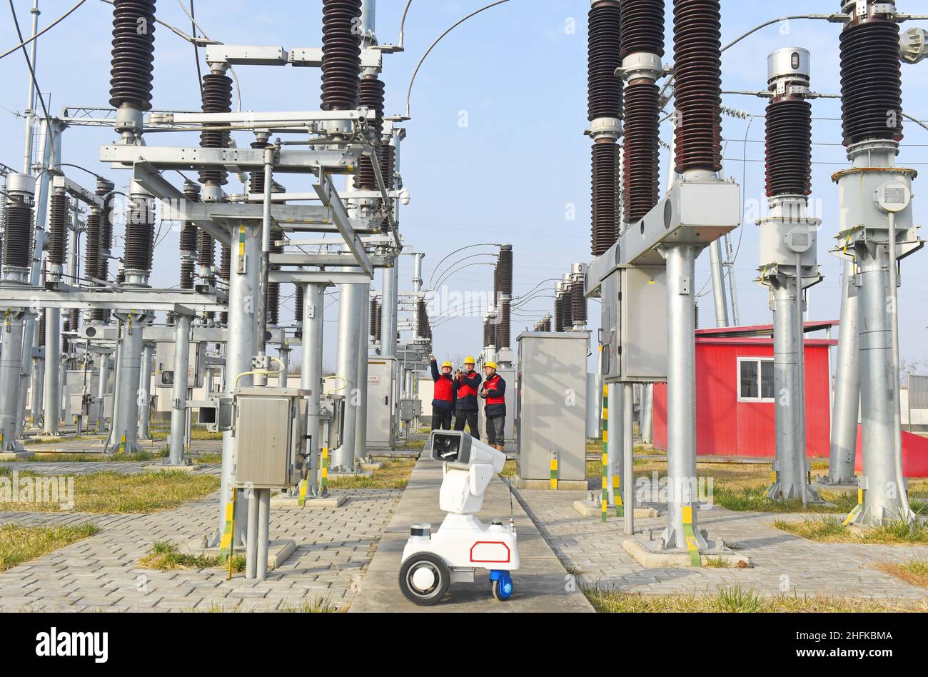 CHUZHOU, CHINE - 17 JANVIER 2022 - Un robot d'inspection intelligent 5G travaille avec le personnel d'exploitation et de maintenance pour inspecter l'équipement d'alimentation Banque D'Images