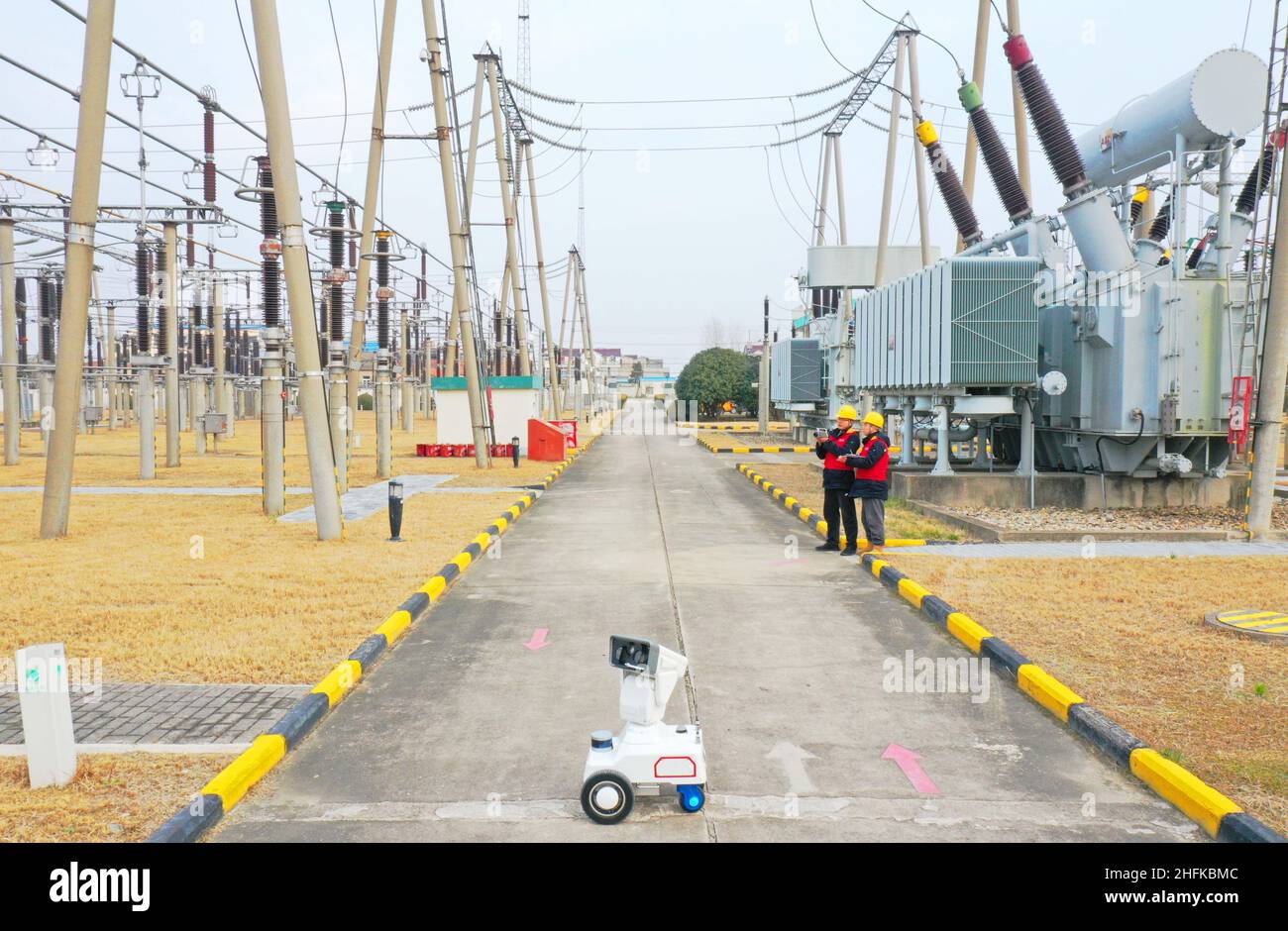CHUZHOU, CHINE - 17 JANVIER 2022 - Un robot d'inspection intelligent 5G travaille avec le personnel d'exploitation et de maintenance pour inspecter l'équipement d'alimentation Banque D'Images