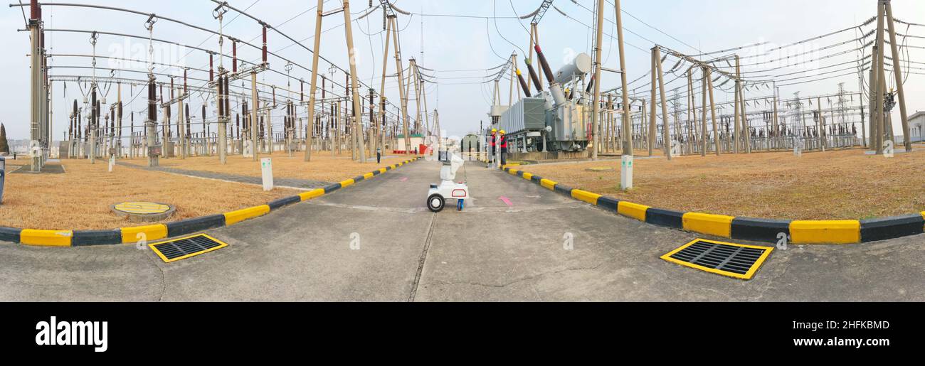 CHUZHOU, CHINE - 17 JANVIER 2022 - Un robot d'inspection intelligent 5G travaille avec le personnel d'exploitation et de maintenance pour inspecter l'équipement d'alimentation Banque D'Images