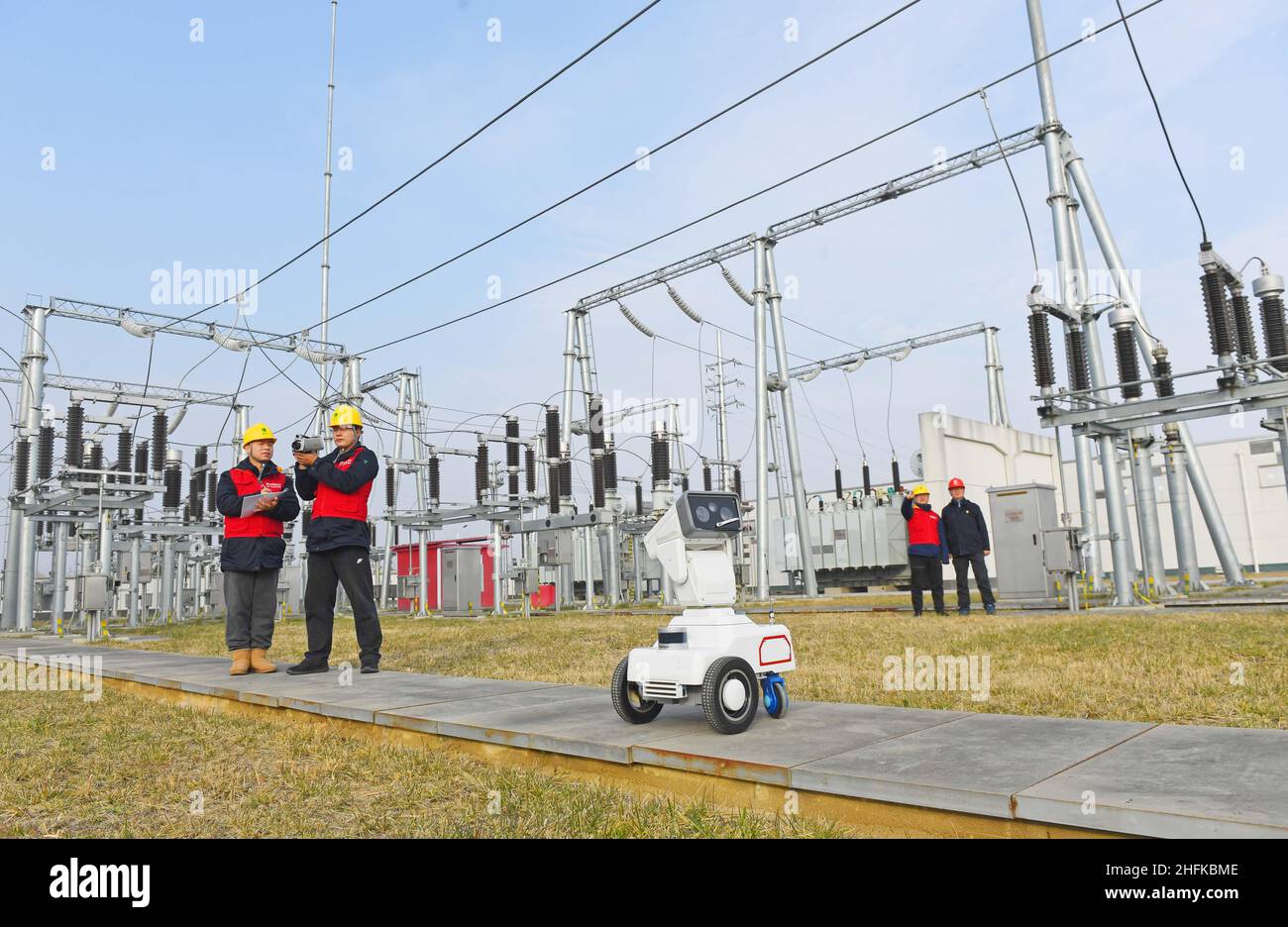 CHUZHOU, CHINE - 17 JANVIER 2022 - Un robot d'inspection intelligent 5G travaille avec le personnel d'exploitation et de maintenance pour inspecter l'équipement d'alimentation Banque D'Images