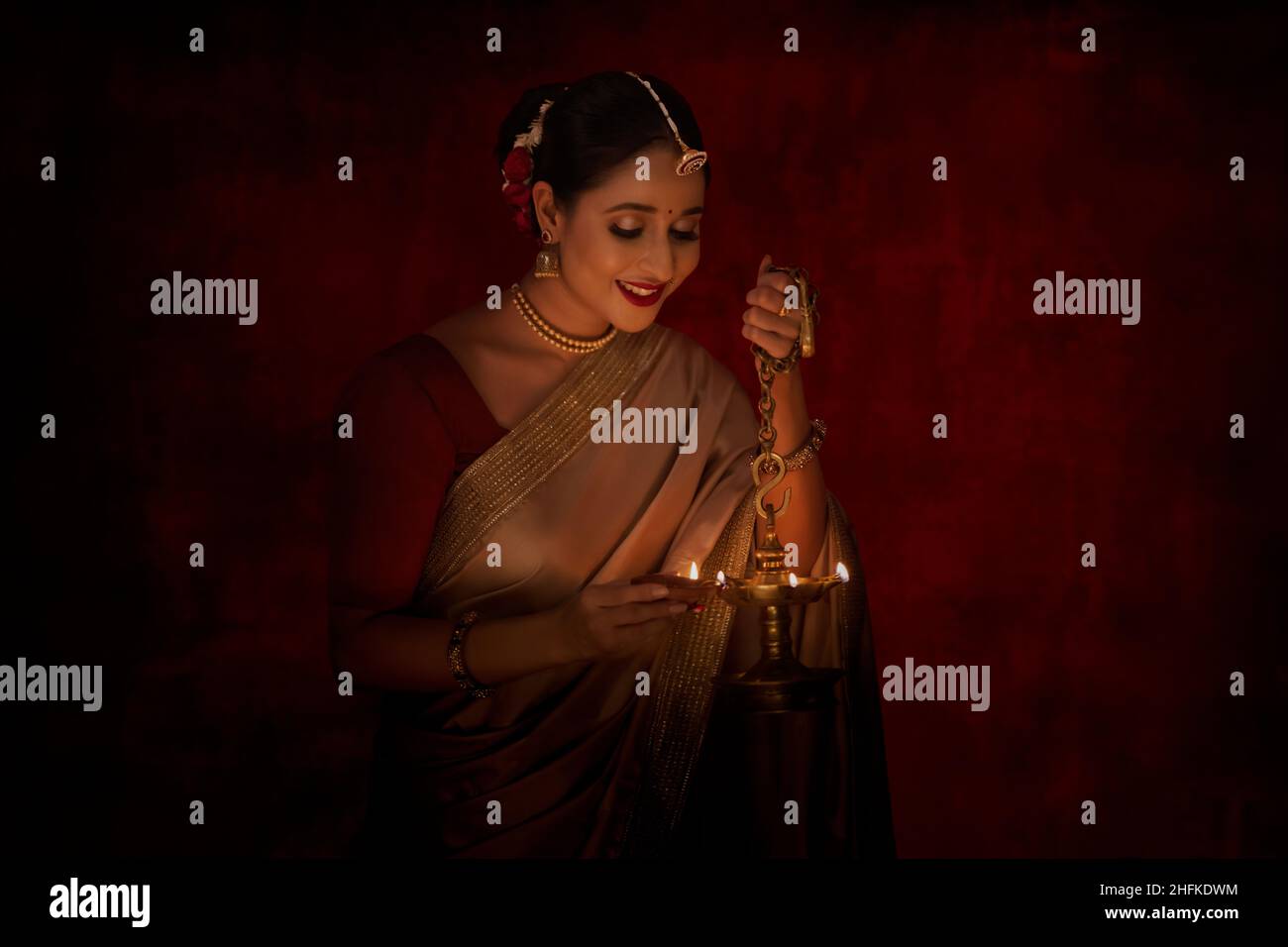 Femme indienne éclairant une lampe avec diya sur Diwali Banque D'Images
