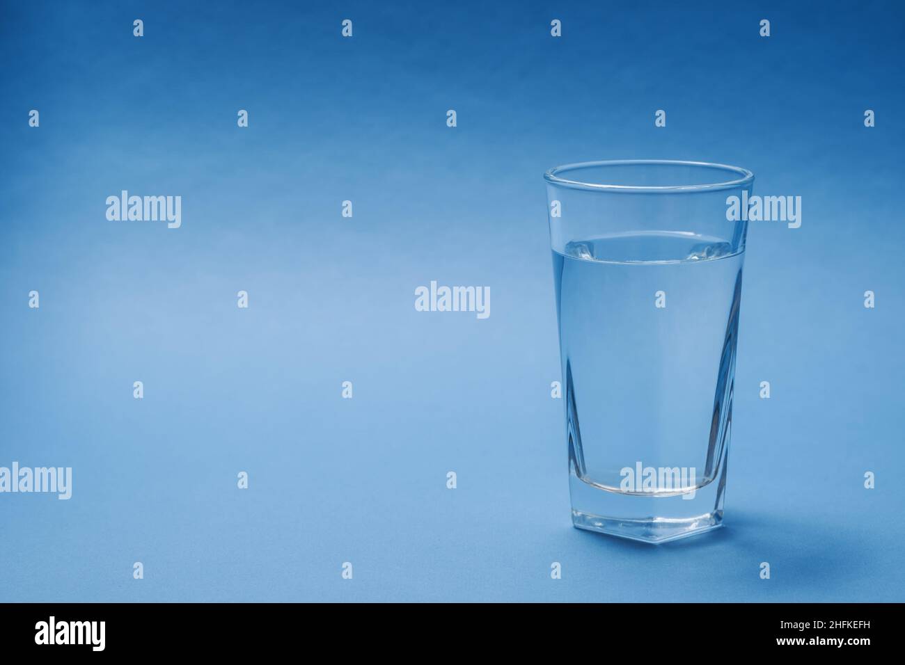 Un verre d'eau sur fond bleu. Banque D'Images