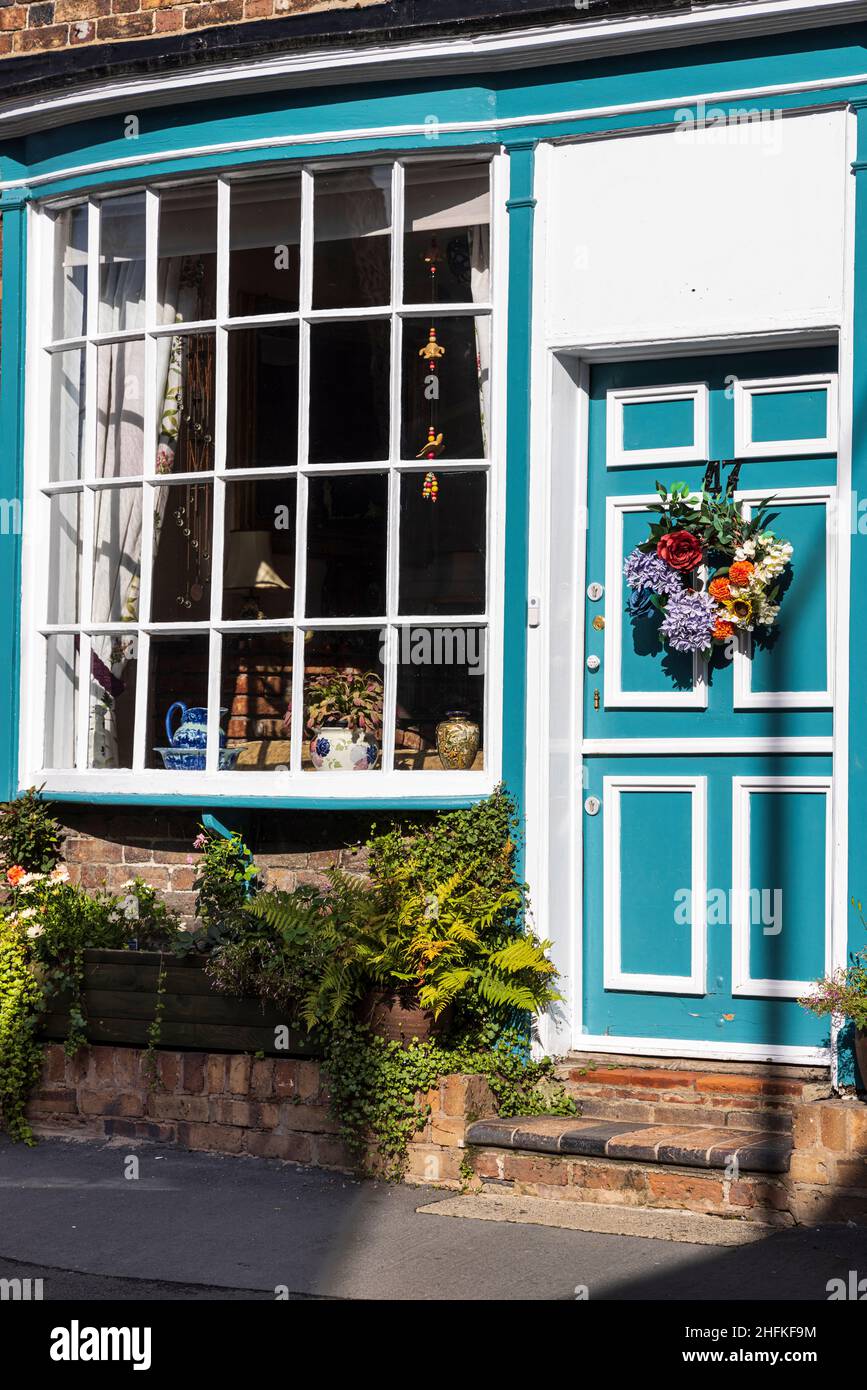 Porte d'entrée avec couronne de fleurs et baie vitrée d'une maison sur la High Street dans la grande ville de Wenlock, Shropshire, Angleterre Banque D'Images